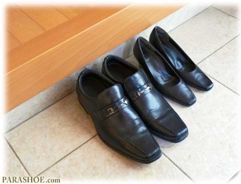 冠婚葬祭での靴選び－玄関先に並んだ黒の革靴（メンズ紳士靴）と黒のパンプス（レディース婦人靴）