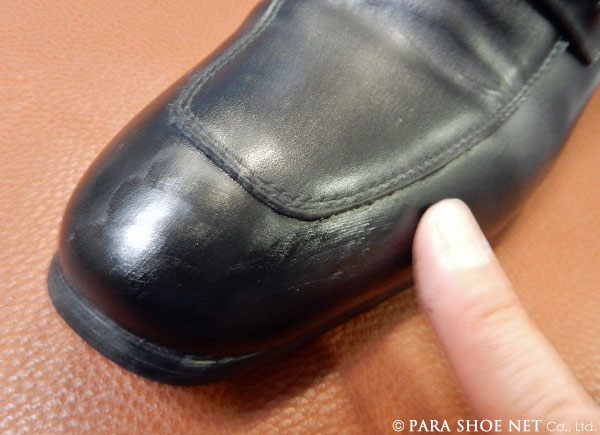 薄めた革靴の傷補修剤を手で塗る